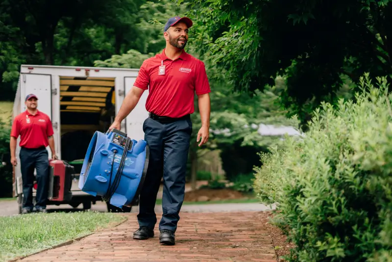 Two members of the Rainbow Restoration team arrive at a property.