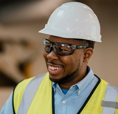 Rainbow Restoration tech with hard hat smiling.