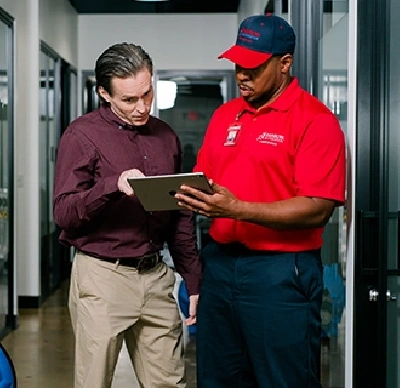 Rainbow Restoration tech showing customer a tablet.