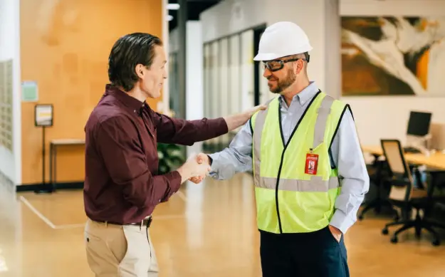 Rainbow tech shaking hands with customer.